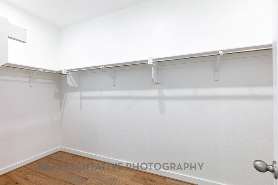 Walk in closet with wood finished floors