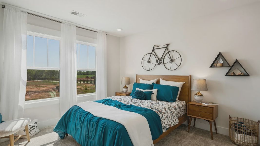 Tasteful bedroom with plush carpet, a walk-in closet, and large windows for abundant natural light in Woodruff, SC