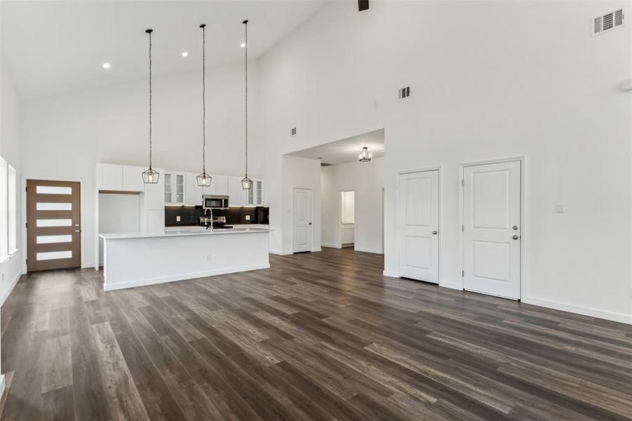 Unfurnished living room with dark wood-type flooring and vaulted ceiling