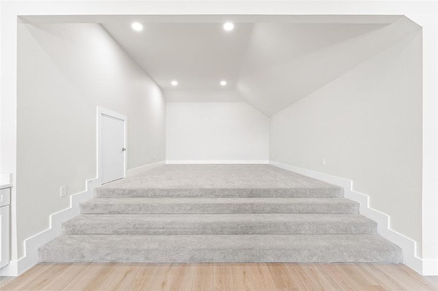 Staircase featuring recessed lighting and wood finished floors Staircase featuring recessed lighting and wood finished floors