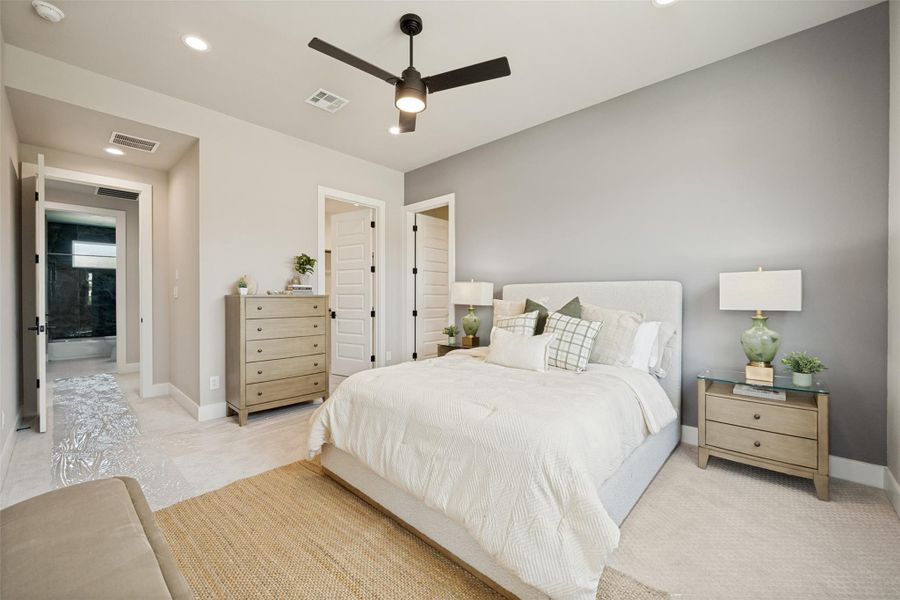 Step into comfort with this primary bedroom, featuring a large bed and direct bathroom access. Step into comfort with this primary bedroom, featuring a large bed and direct bathroom access.