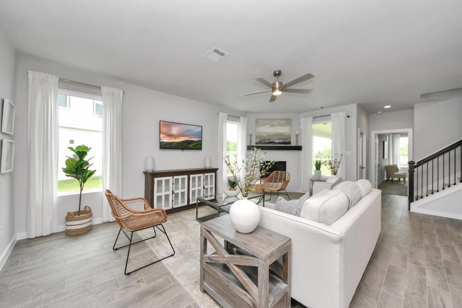 Gather the family and guests together in your lovely living room! Featuring soaring high ceilings, recessed lighting, ceiling fan, custom paint, gorgeous floors, and large windows that provide plenty of natural lighting throughout the day. Sample photo of completed home with similar floor plan. Actual colors and selections may vary.
