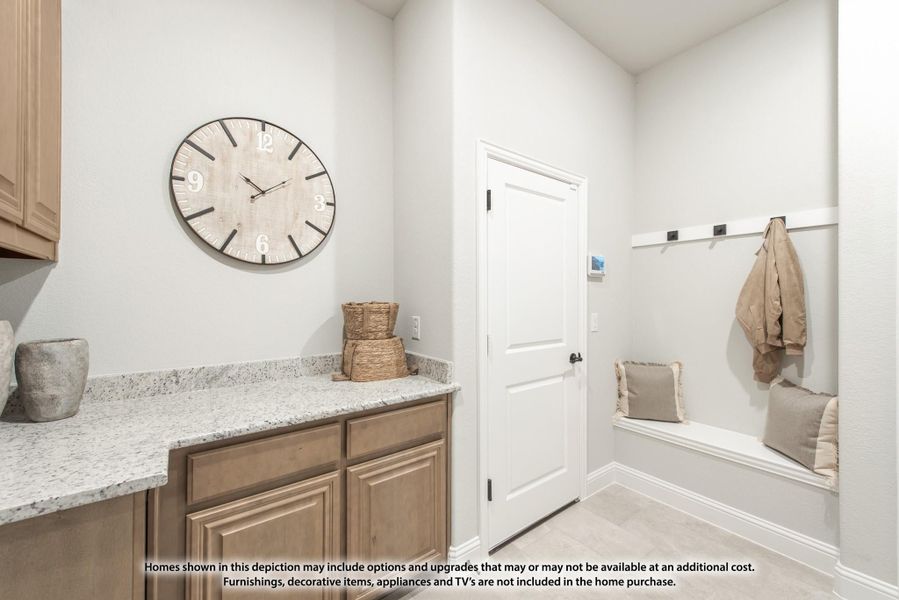 Mudroom with built-in bench, wall hooks, and adjacent cabinet with granite countertop Mudroom with built-in bench, wall hooks, and adjacent cabinet with granite countertop