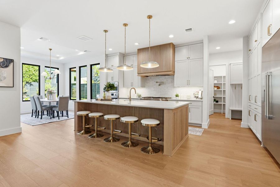 Kitchen with a kitchen breakfast bar, white cabinets, pendant lighting, light wood-type flooring, and recessed lighting Kitchen with a kitchen breakfast bar, white cabinets, pendant lighting, light wood-type flooring, and recessed lighting