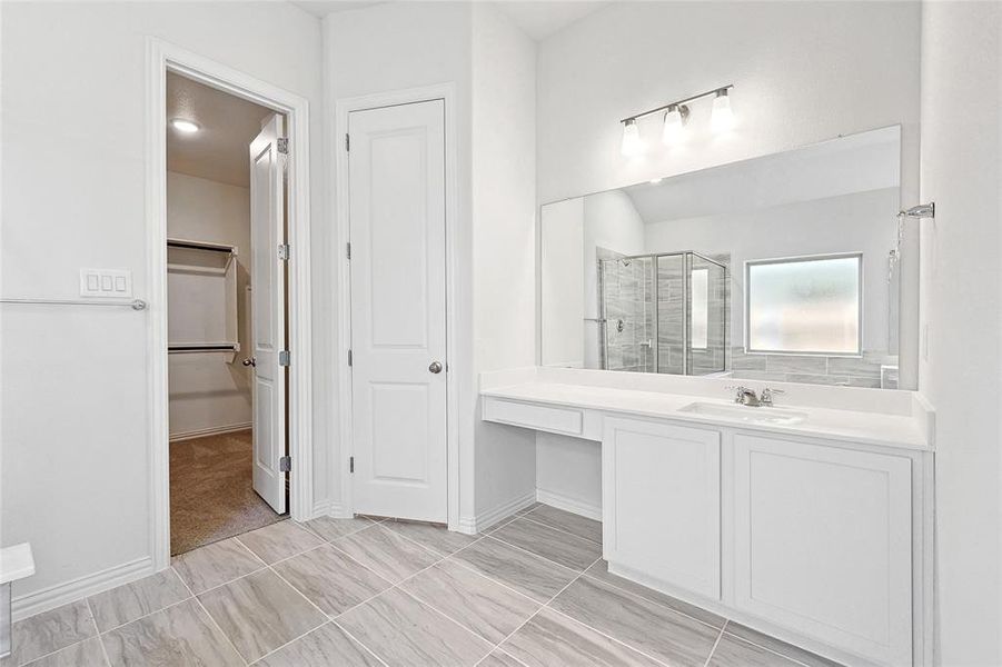 Bathroom featuring vanity, tile patterned floors, and walk in shower