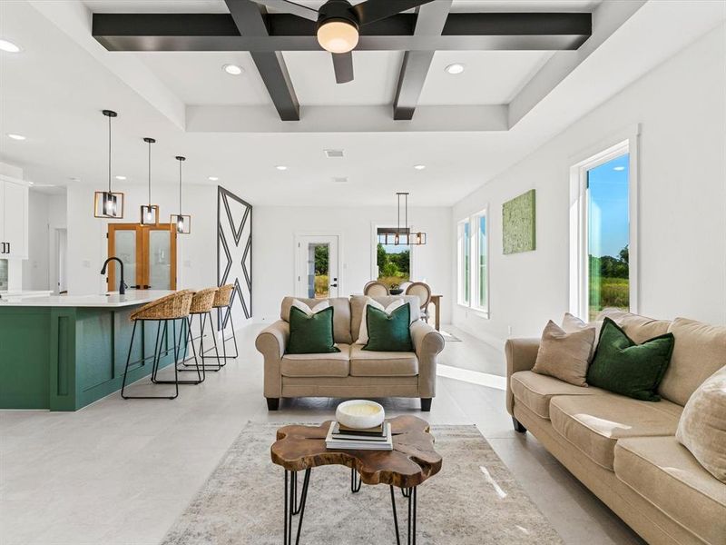 Living room with beam ceiling, coffered ceiling, recessed lighting, and a ceiling fan