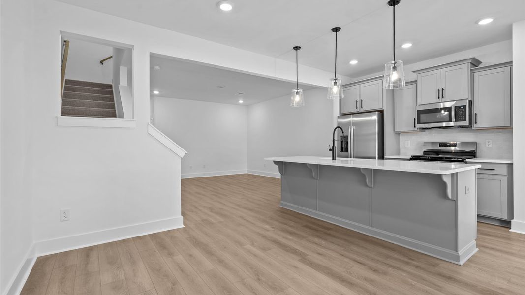 Accomplished kitchen design featuring pendant lighting above a statement island for both prep and gathering
