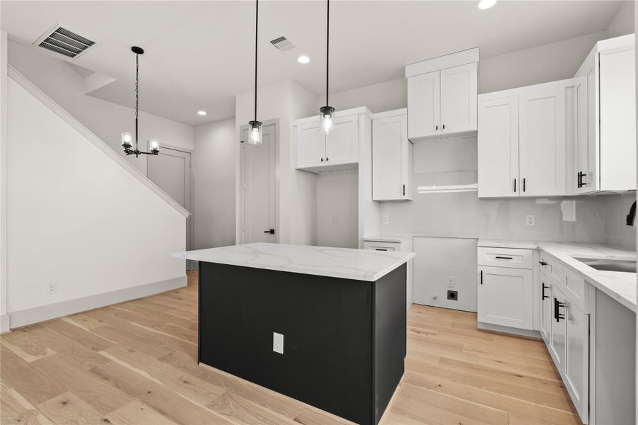 Kitchen and dining connected — chandelier, island, and staircase all in view Kitchen and dining connected — chandelier, island, and staircase all in view