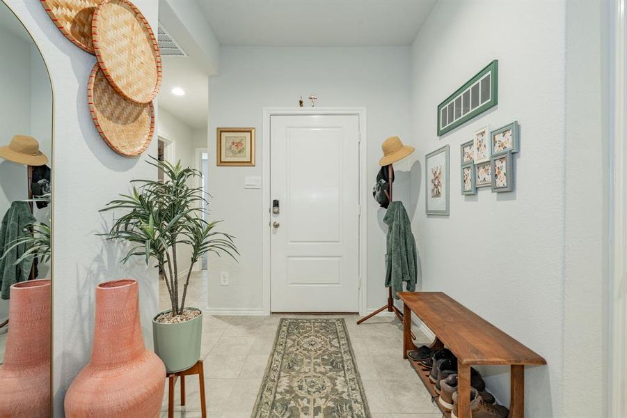 Foyer featuring light tile patterned floors and baseboards