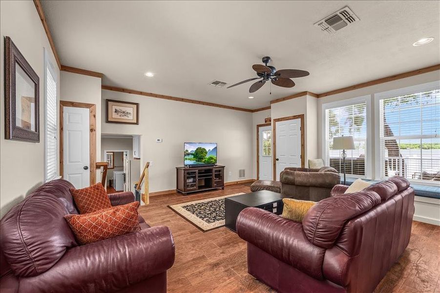 Living room featuring wood finished floors, a ceiling fan, recessed lighting, and ornamental molding
