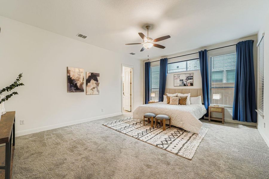 Carpeted bedroom featuring a ceiling fan and baseboards Carpeted bedroom featuring a ceiling fan and baseboards