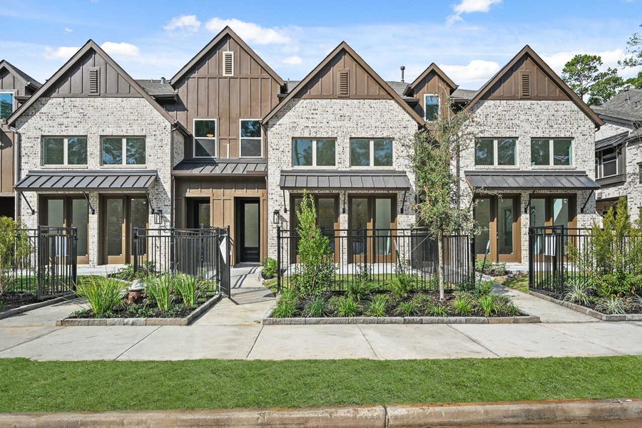 Front exterior of a new home in Woodforest Townhomes: Townhomes:  The Patios, Montgomery, TX, highlighting curb appeal (Image 1).