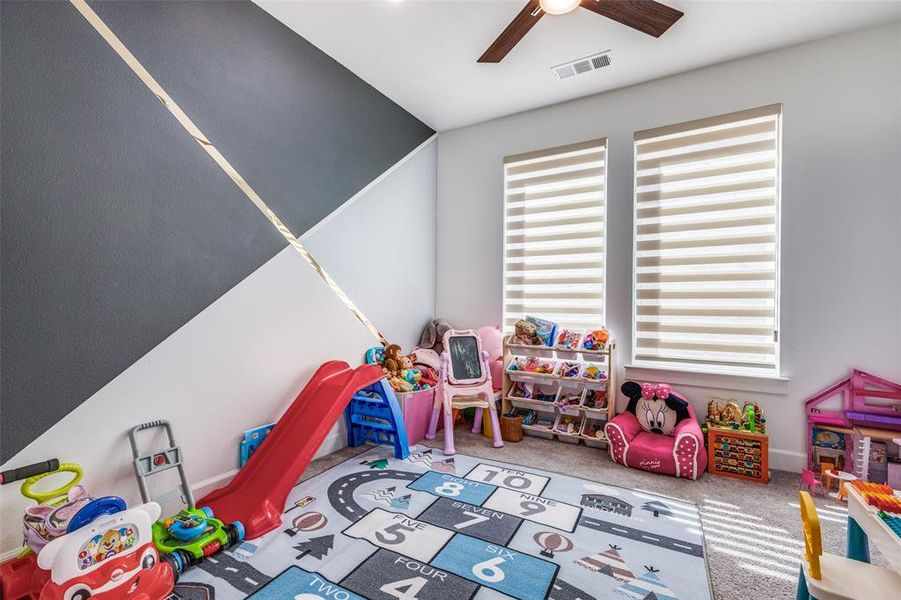 Bright and versatile office featuring an accent wall, windows for abundant natural light, carpeted floors, and a lighted ceiling fan. French doors provide privacy, and the space easily adapts—currently used as a child’s playroom! Bright and versatile office featuring an accent wall, windows for abundant natural light, carpeted floors, and a lighted ceiling fan. French doors provide privacy, and the space easily adapts—currently used as a child’s playroom!