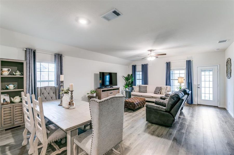 Dining room with ceiling fan, wood-type flooring, and vaulted ceiling