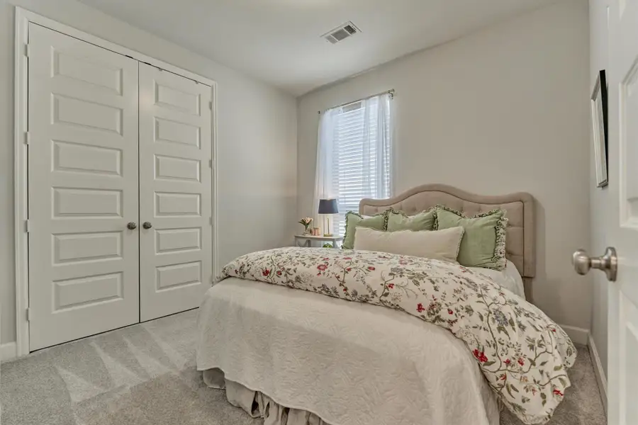 This spacious secondary bedroom with upgraded carpet and pad. A large double door closet provides good storage.