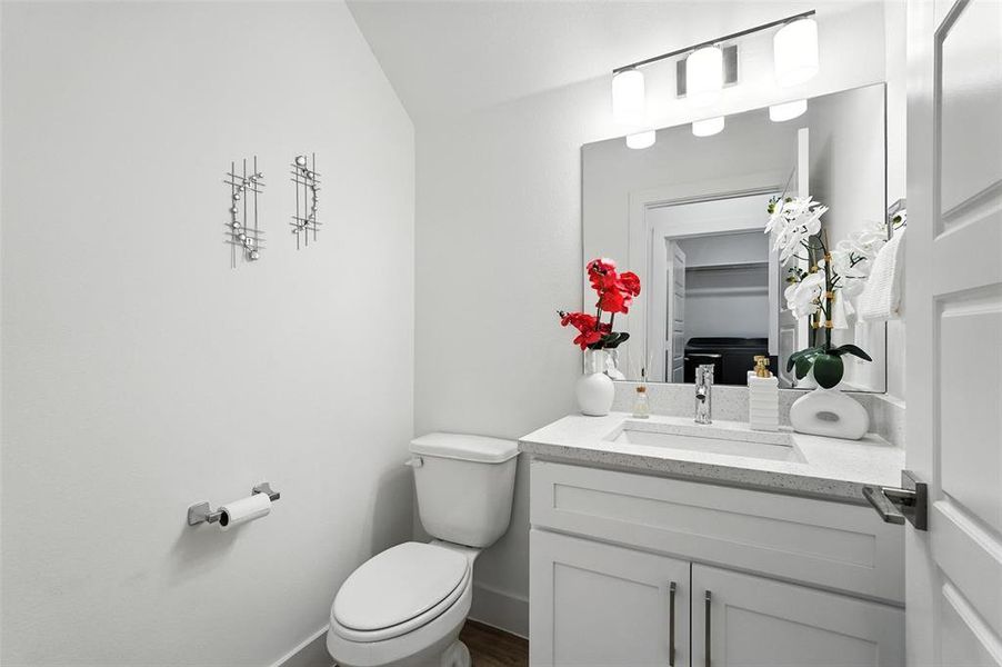 Half bath with vanity and toilet found downstairs