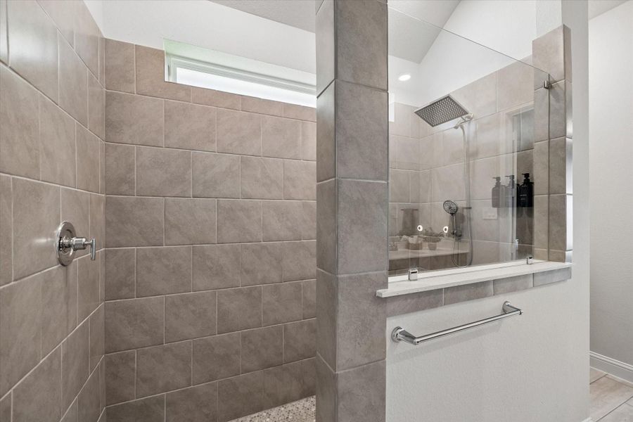 Spacious walk-in shower featuring modern fixtures, frameless glass enclosure, and custom tile work. Spacious walk-in shower featuring modern fixtures, frameless glass enclosure, and custom tile work.