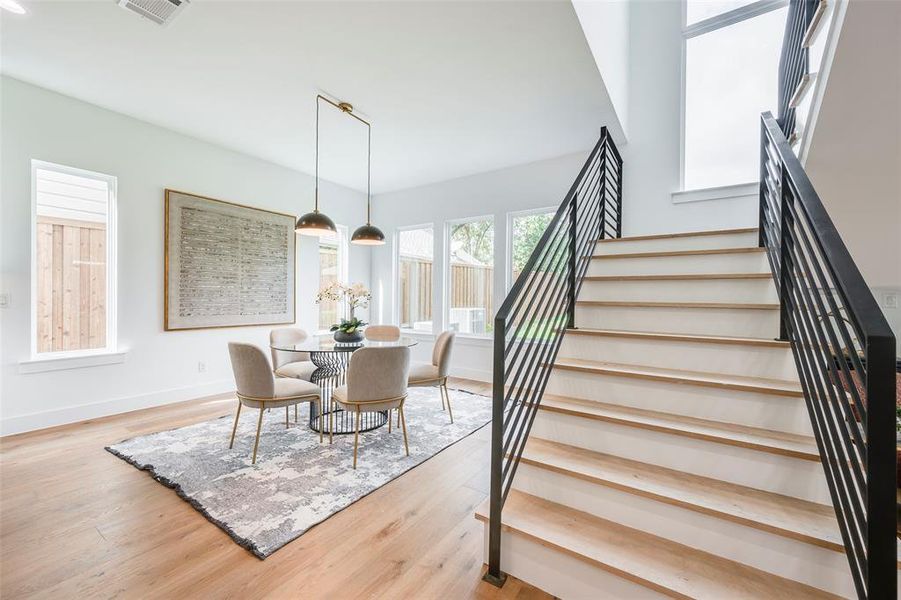 Dining room with light wood-style floors and stairway Dining room with light wood-style floors and stairway