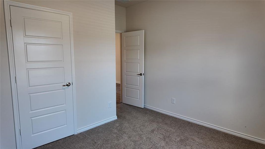 Unfurnished bedroom featuring carpet flooring and baseboards