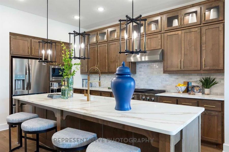 Kitchen with decorative backsplash, hanging light fixtures, a kitchen island with sink, dark wood-type flooring, and recessed lighting Kitchen with decorative backsplash, hanging light fixtures, a kitchen island with sink, dark wood-type flooring, and recessed lighting