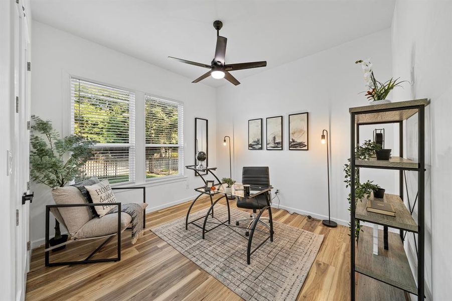 Bedroom with ceiling fan, multiple windows, and hardwood / wood-style floors