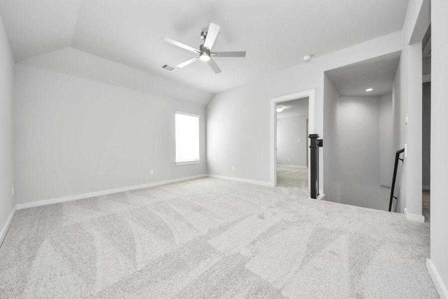 Ascend to relaxation in this fantastic game room! Ideal for both casual gatherings and adult gaming, it boasts plush carpet, lofty ceilings, custom paint, and ample windows for abundant natural light. Sample photo of completed home with similar floor plan. Actual colors and selections may vary.