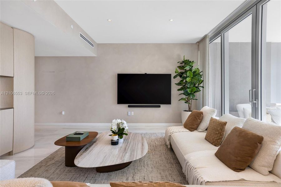Floor-to-ceiling glass sliding doors, light-toned wood-finish cabinetry, neutral plaster-style walls, recessed ceiling lighting, and light-toned flooring