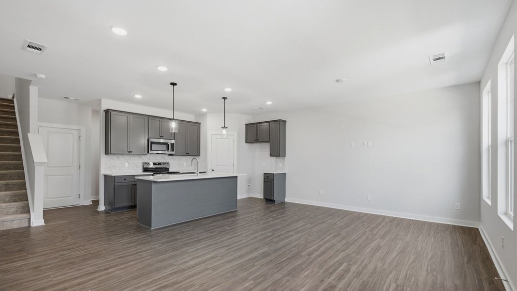 Kitchen with island and pantry door next to entryway
