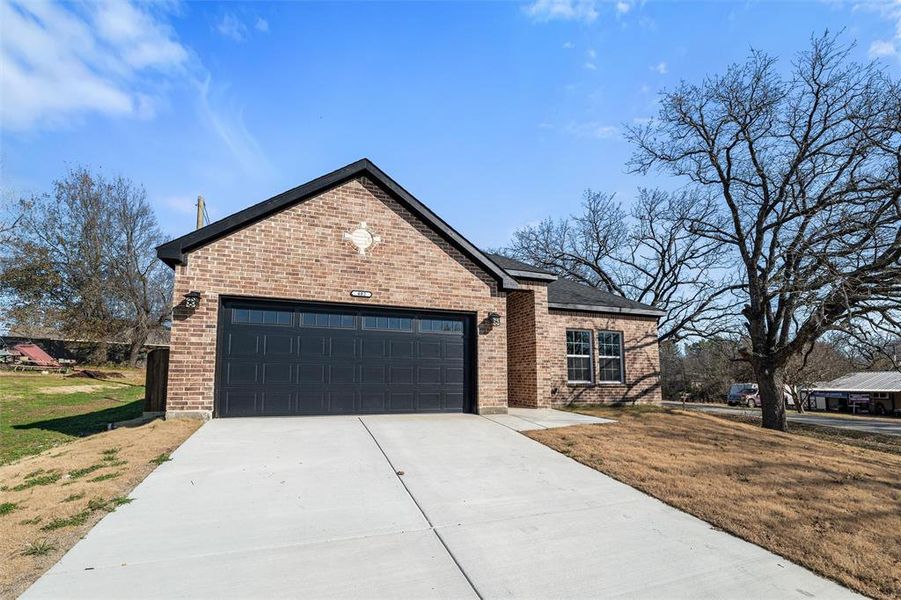 View of front of house featuring a garage and a front lawn