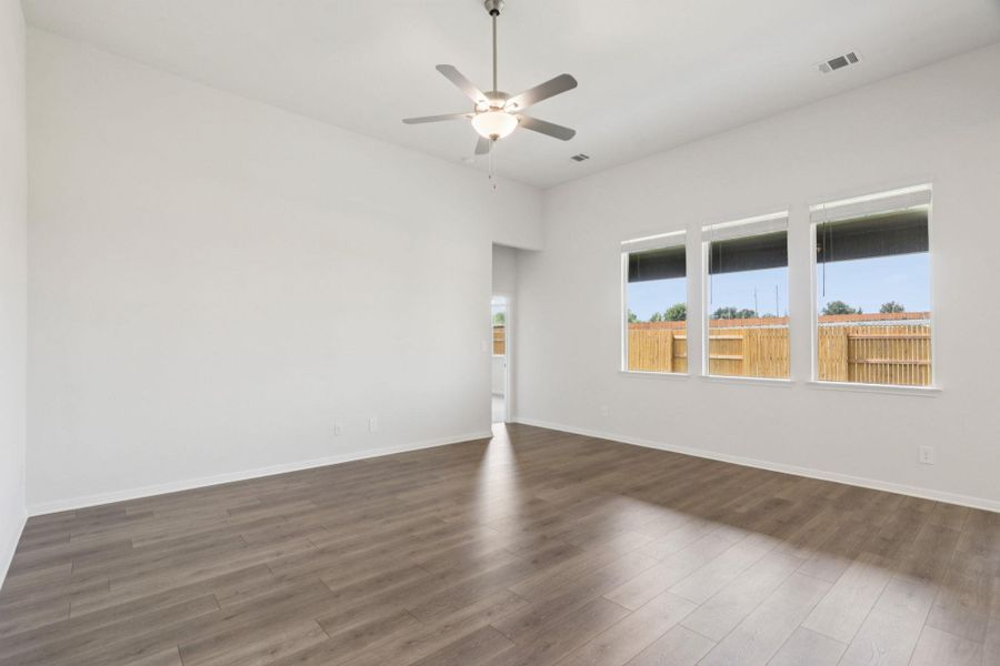 Spare room featuring dark wood-style flooring and a ceiling fan Spare room featuring dark wood-style flooring and a ceiling fan