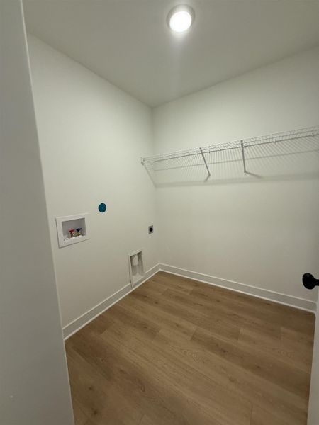 Laundry room featuring dark wood-type flooring, hookup for an electric dryer, and hookup for a washing machine