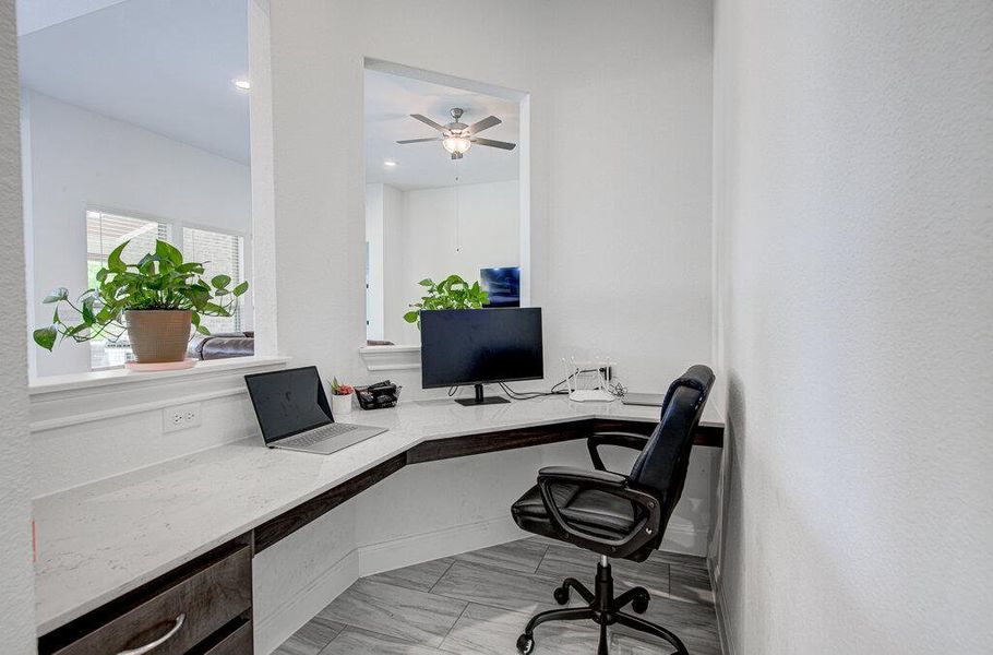 A built-in corner desk with stone counters integrates seamlessly into this modern work alcove. A built-in corner desk with stone counters integrates seamlessly into this modern work alcove.