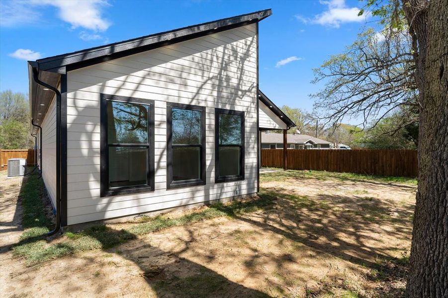 View of side of property with a fenced backyard and a central air condition unit
