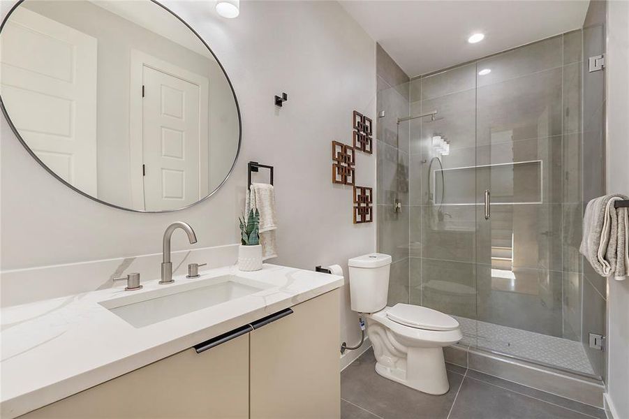 Bathroom featuring vanity, an enclosed shower, tile patterned flooring, and toilet