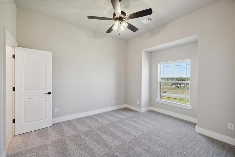 Carpeted spare room with ceiling fan