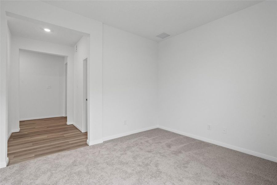 View from the Den looking into the hallway to Primary Bedroom (right) and laundry room (left). View from the Den looking into the hallway to Primary Bedroom (right) and laundry room (left).