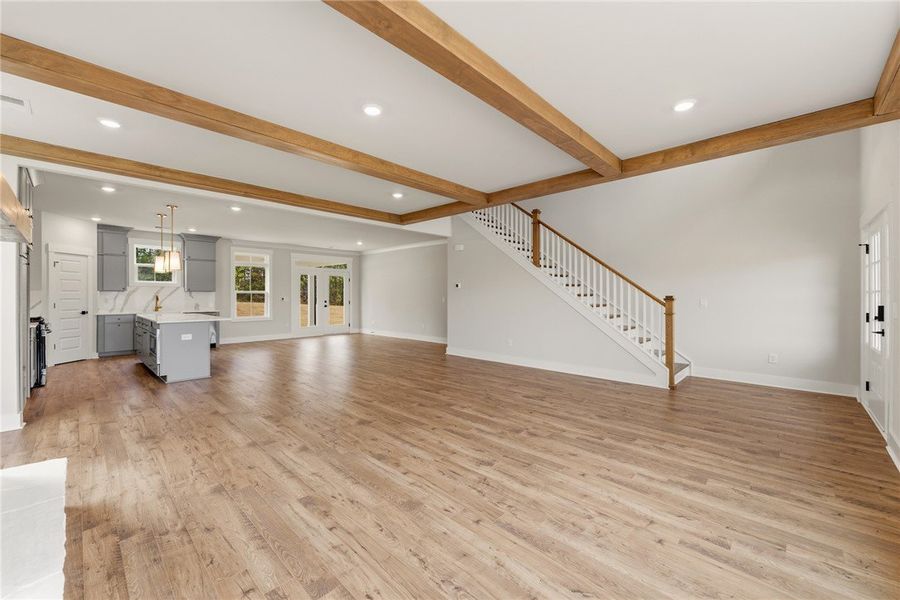 Bright open-concept living space with exposed beam