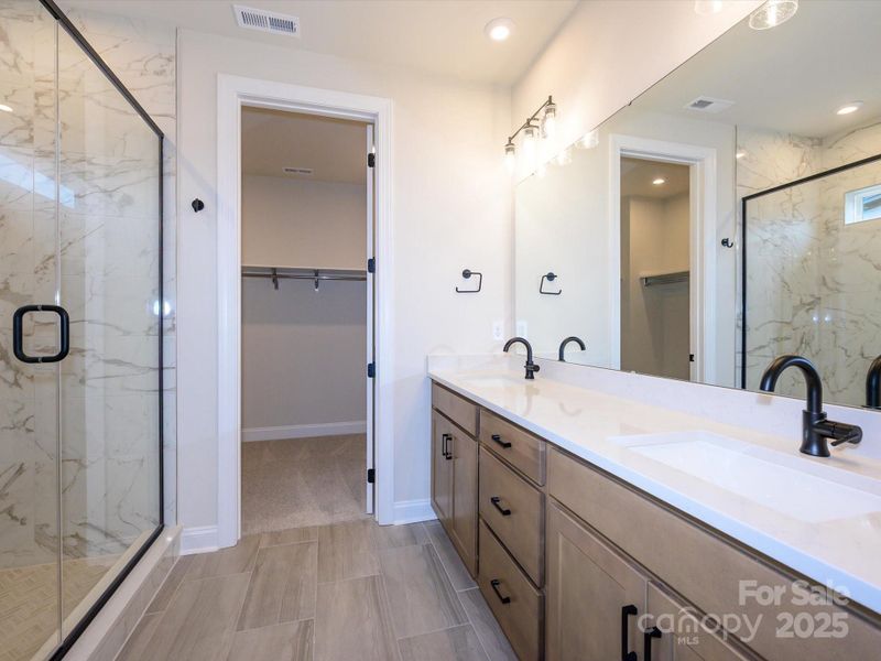 En Suite Primary Bath with Dual Vanity and Loads of Storage Leading to Walk-In Closet.