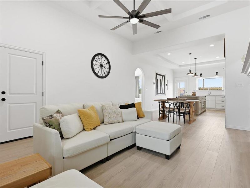 This living room with coffered ceilings and natural light is welcoming to all!