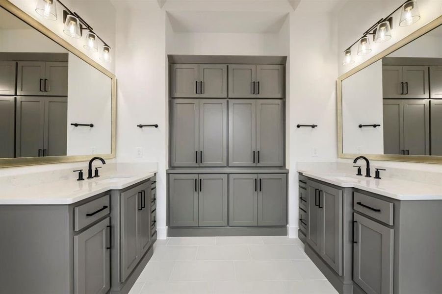 This bathroom features dual vanity units with grey cabinetry, white countertops, and black fixtures