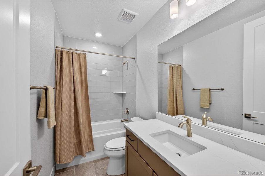 Basement Bathroom – Full basement bath with contemporary finishes, including a quartz vanity, brushed-nickel fixtures, and a tiled shower-tub combination