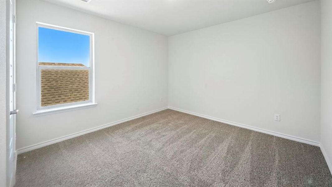 Carpeted spare room featuring baseboards