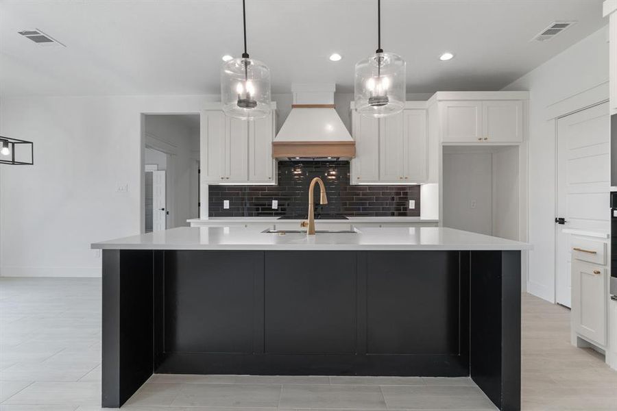 Kitchen with appliances with stainless steel finishes, backsplash, light countertops, recessed lighting, and white cabinets