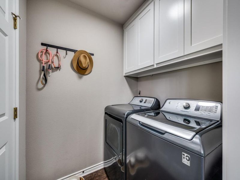 Laundry area featuring cabinet space, separate washer and dryer, and baseboards. The door on the left is to the big pantry. Laundry area featuring cabinet space, separate washer and dryer, and baseboards. The door on the left is to the big pantry.