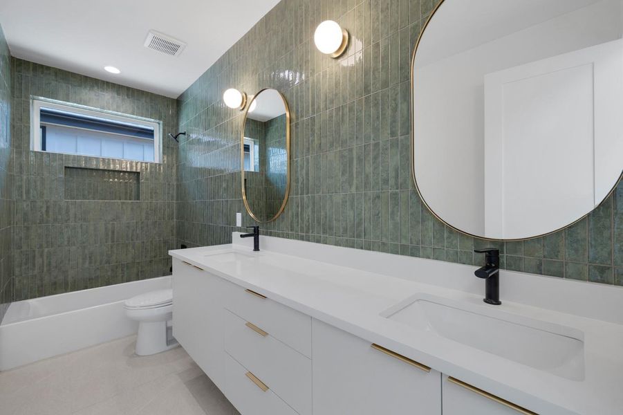Full bathroom featuring tile walls, double vanity, washtub / shower combination, light tile patterned floors, and recessed lighting Full bathroom featuring tile walls, double vanity, washtub / shower combination, light tile patterned floors, and recessed lighting