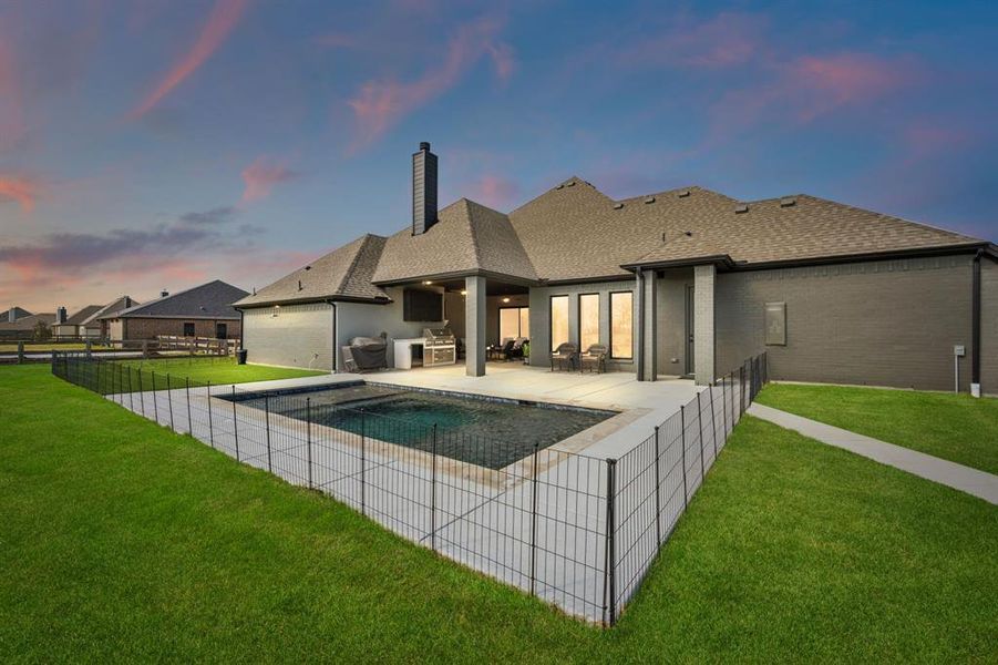 Rear view of house with brick siding, a shingled roof, exterior kitchen, a patio area, and a chimney