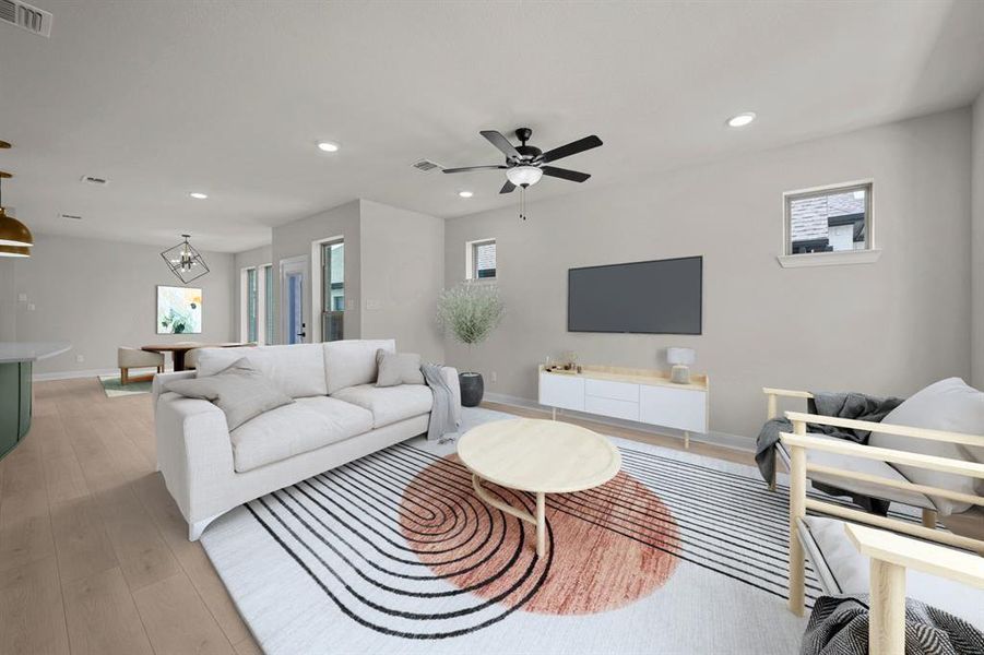 Living room with light wood-style floors, healthy amount of natural light, and ceiling fan