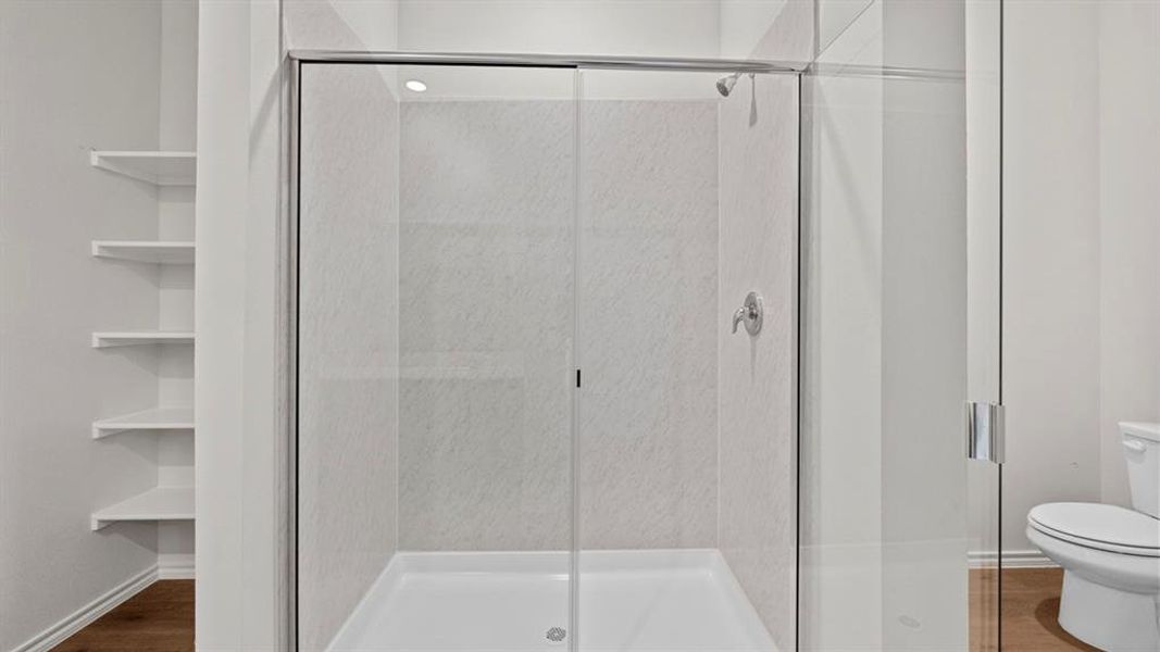 Bathroom featuring a shower stall and dark wood-type flooring