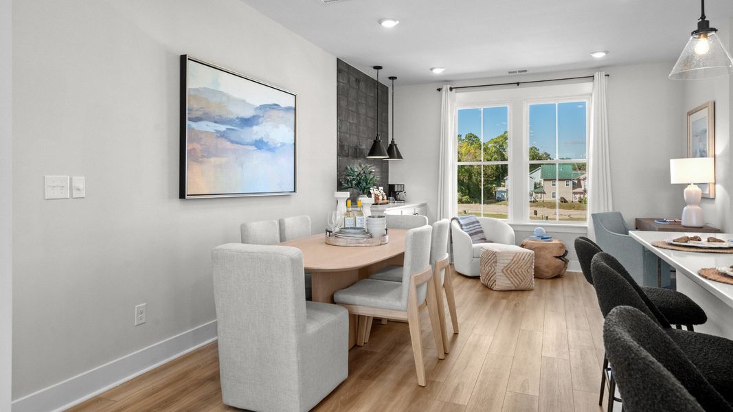 Island kitchen & dining area with 2 large windows in a DRB Homes Brookgreen model home