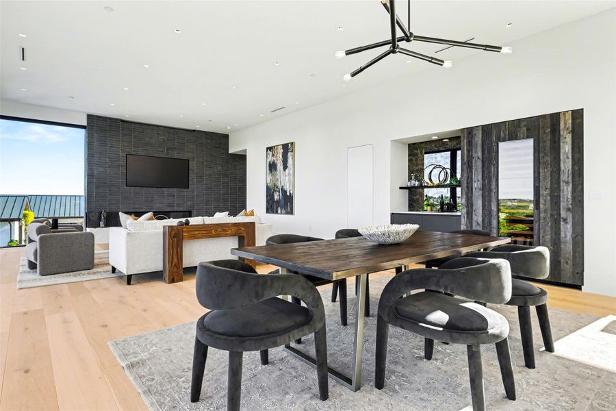 Dining space with light wood-style flooring, healthy amount of natural light, and a chandelier